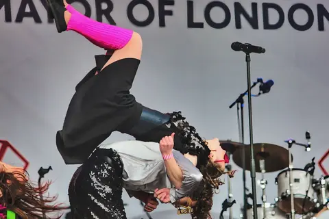 West End Kids performers doing an acrobatic lift on the Mayor of London stage