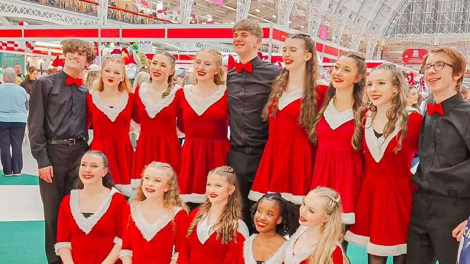 The West End Kids troupe in festive costumes posing for a group photo at the Ideal Home Show