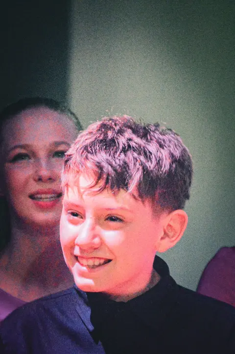 A West End Kids Troupe member smiling on stage